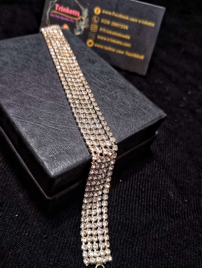 A close-up image of a chain bracelet with four rows of zircon stones, emitting a dazzling and glamorous aura