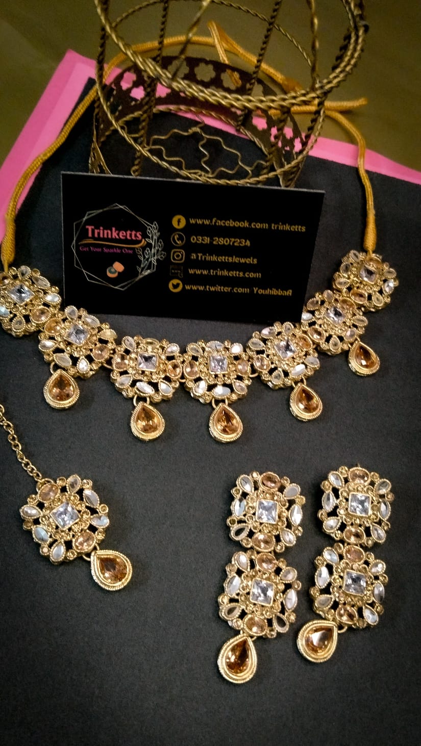 Exquisite Jewelry Set with Transparent and Champagne Stones on geometric pattrens having Teeka, Earrings, and Neckpiece"
