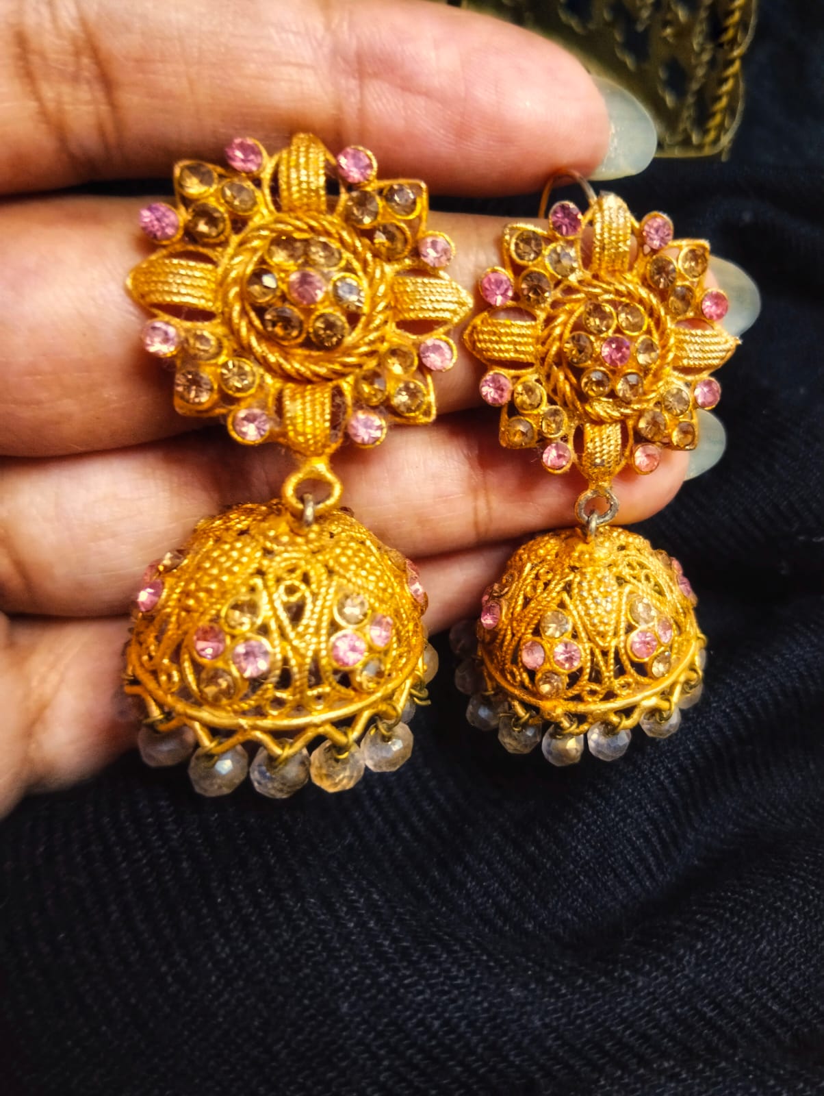 Handcrafted Pakistani earrings in the style of Manjoos: desi chic jhumkis, resembling the richness of gold, adorned with an array of colored stones and beads. A fusion of tradition and modern aesthetics, perfect for adding elegance to any occasion.