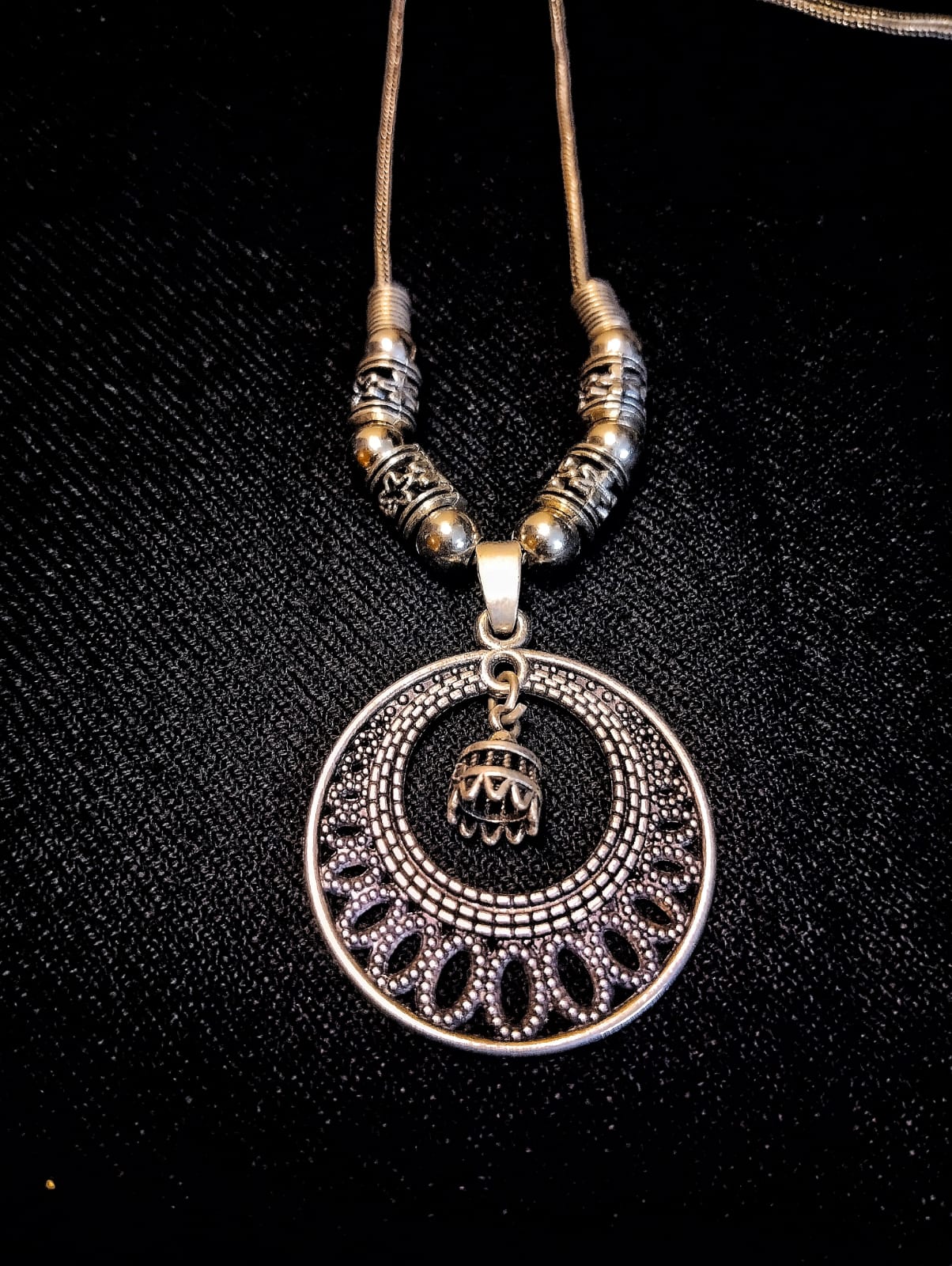 Close-up View of Oxidized Silver Crescent Circle Pendant with Hanging Bell Charm