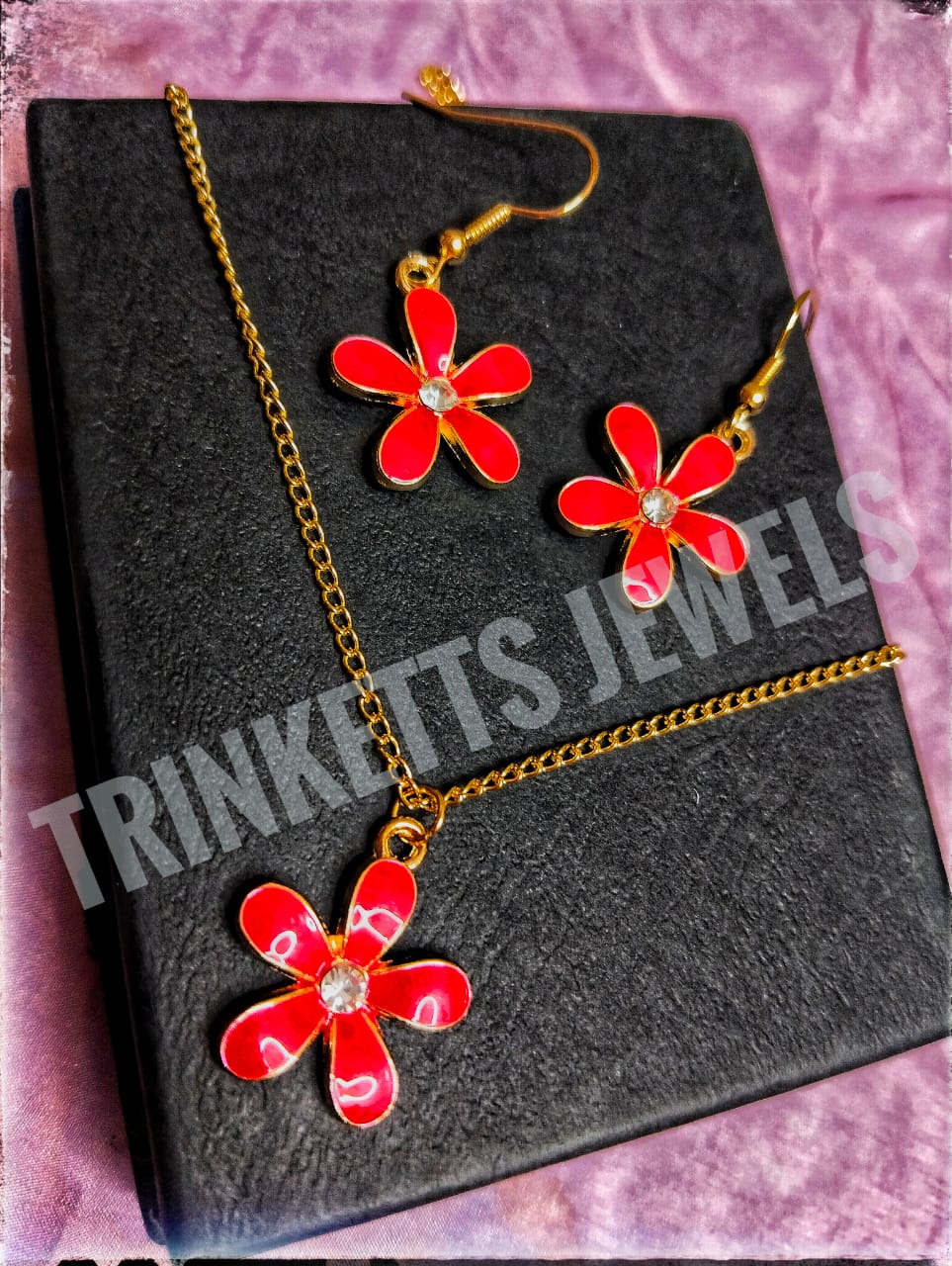 Trinketts Golden Combo Set: red floral charm - A stylish combo featuring matching earrings and pendant with a golden polish. The pendant mirrors the unique design of the earrings. Ideal for both kids and teens, this funky set adds a touch of individuality to your style. Perfect for Pakistani fashion enthusiasts seeking a blend of elegance and playfulness.