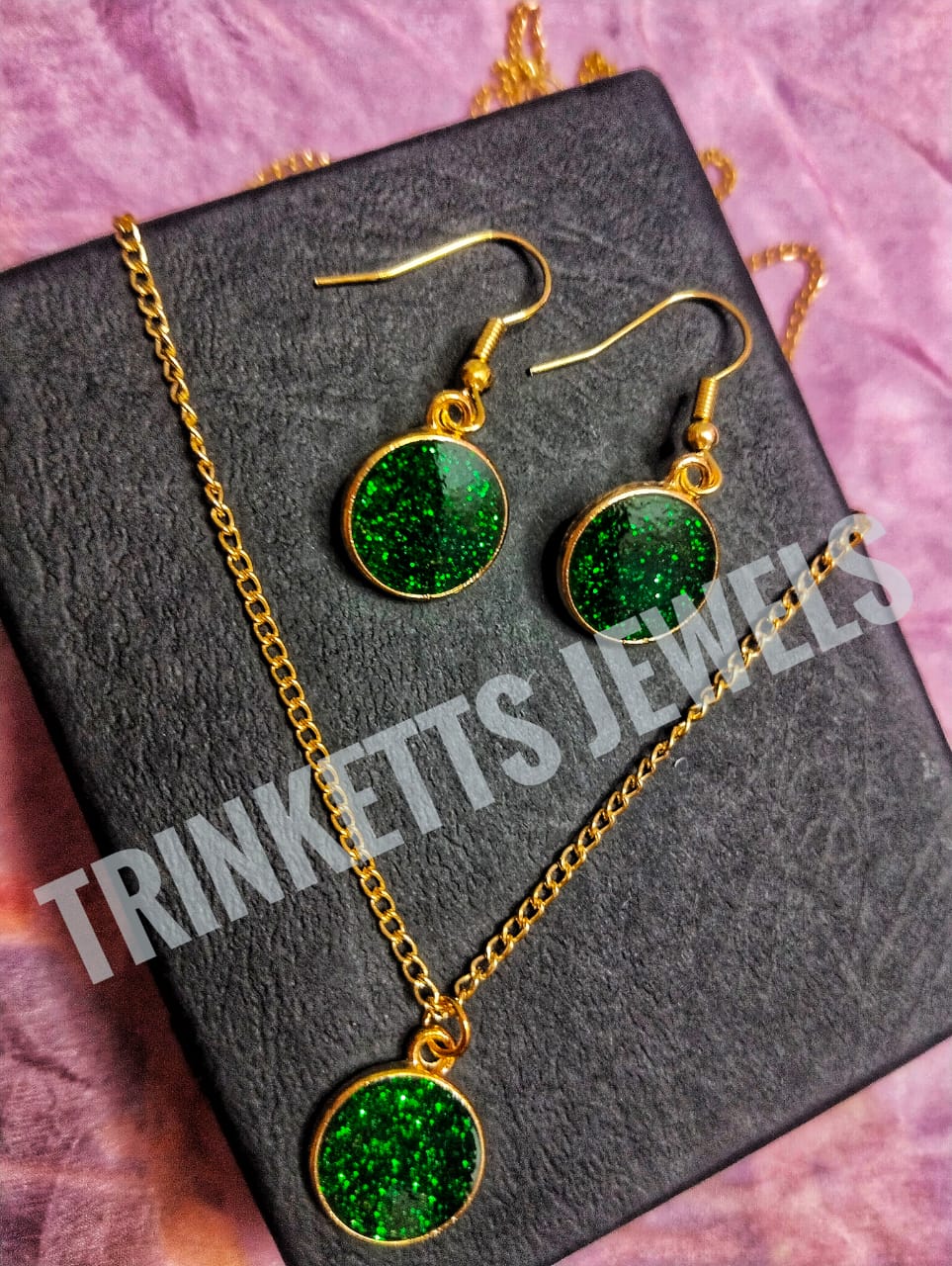 Trinketts Golden Combo Set: glittery green - A stylish combo featuring matching earrings and pendant with a golden polish. The pendant mirrors the unique design of the earrings. Ideal for both kids and teens, this funky set adds a touch of individuality to your style. Perfect for Pakistani fashion enthusiasts seeking a blend of elegance and playfulness.