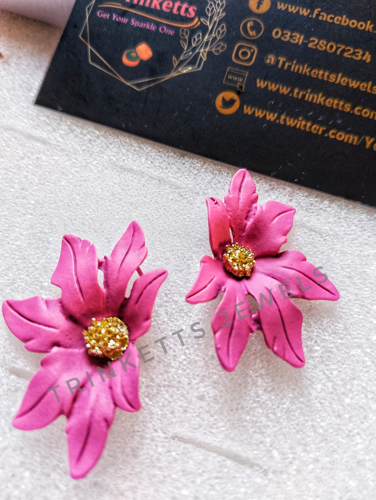Handcrafted pink clay floral studs with leafy petals and a center rhinestone in copper. Artisanal jewelry, blending nature-inspired design with the warmth of clay craftsmanship.