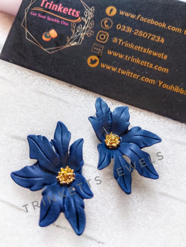 Handcrafted navy blue clay floral studs with leafy petals and a center rhinestone in copper. Artisanal jewelry, blending nature-inspired design with the warmth of clay craftsmanship.