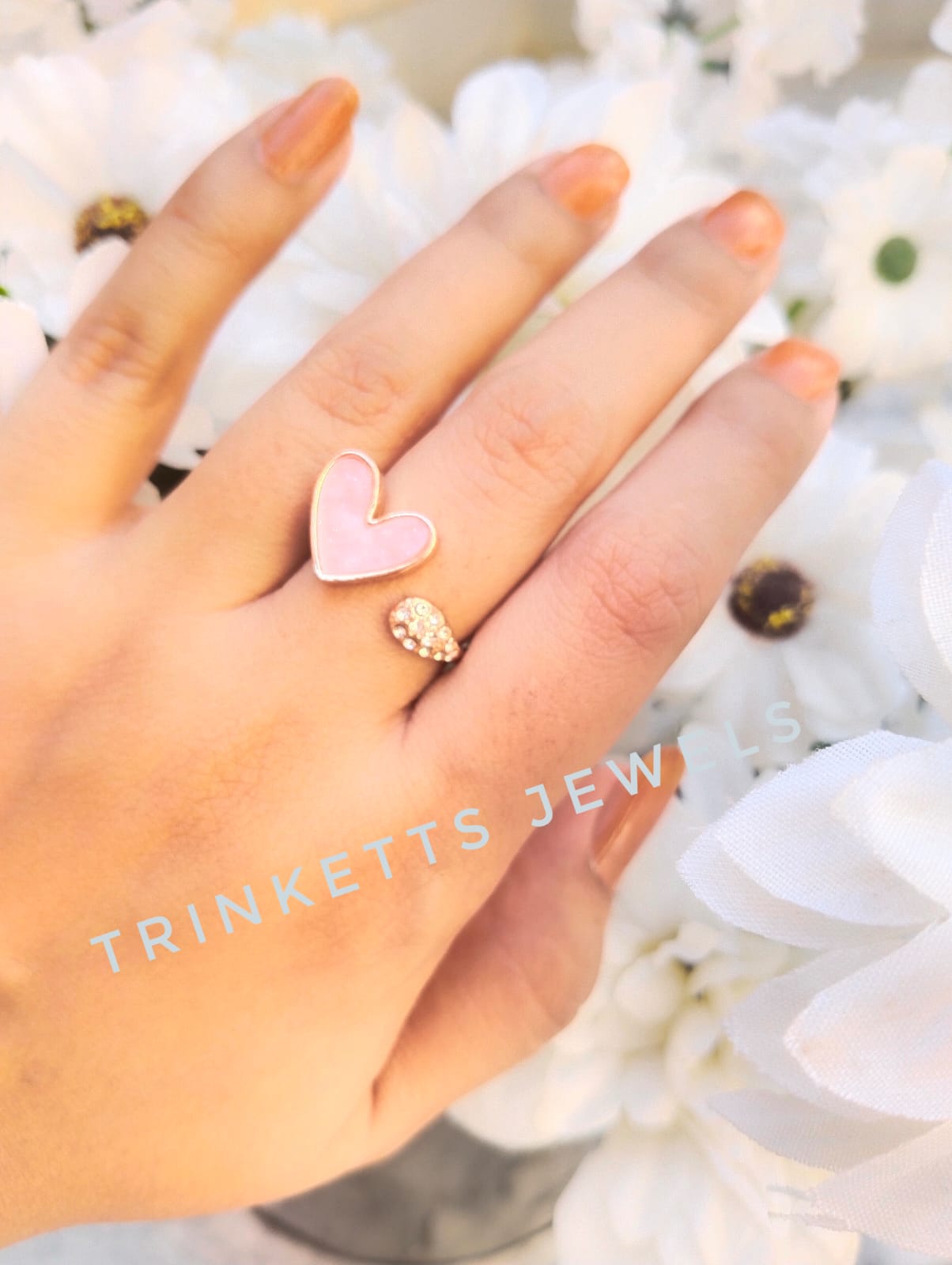 Adjustable baby pink heart ring with glittery marble effect stone framed in gold polish on one end and zircon stones in an oval shape on the other. Elegant and versatile, perfect for adding a touch of glamour to any outfit.