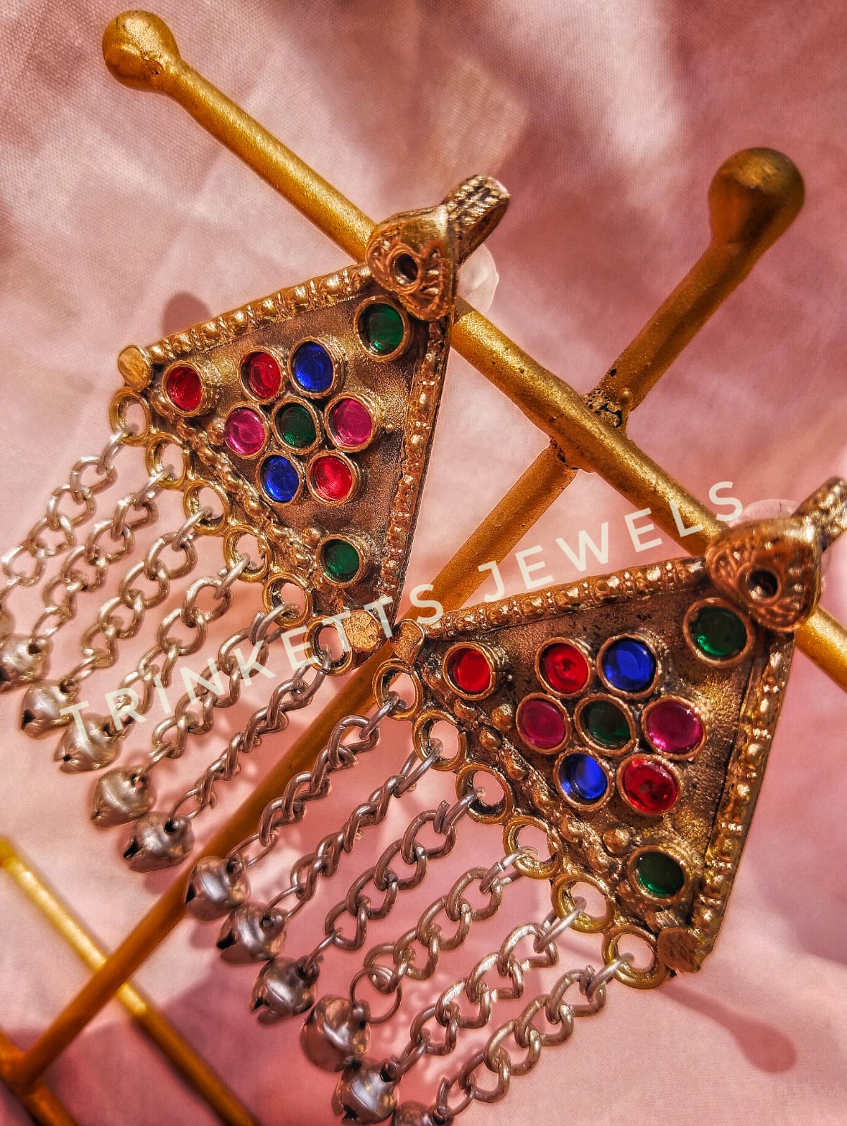 Trinketts' Afghani Style Earrings in a captivating triangular design. Heavy metal craftsmanship with colorful stones arranged in a floral pattern, accompanied by ghungroo-adorned chain hangings. The perfect fusion of tradition and trend, now available in a vibrant multi-color palette.